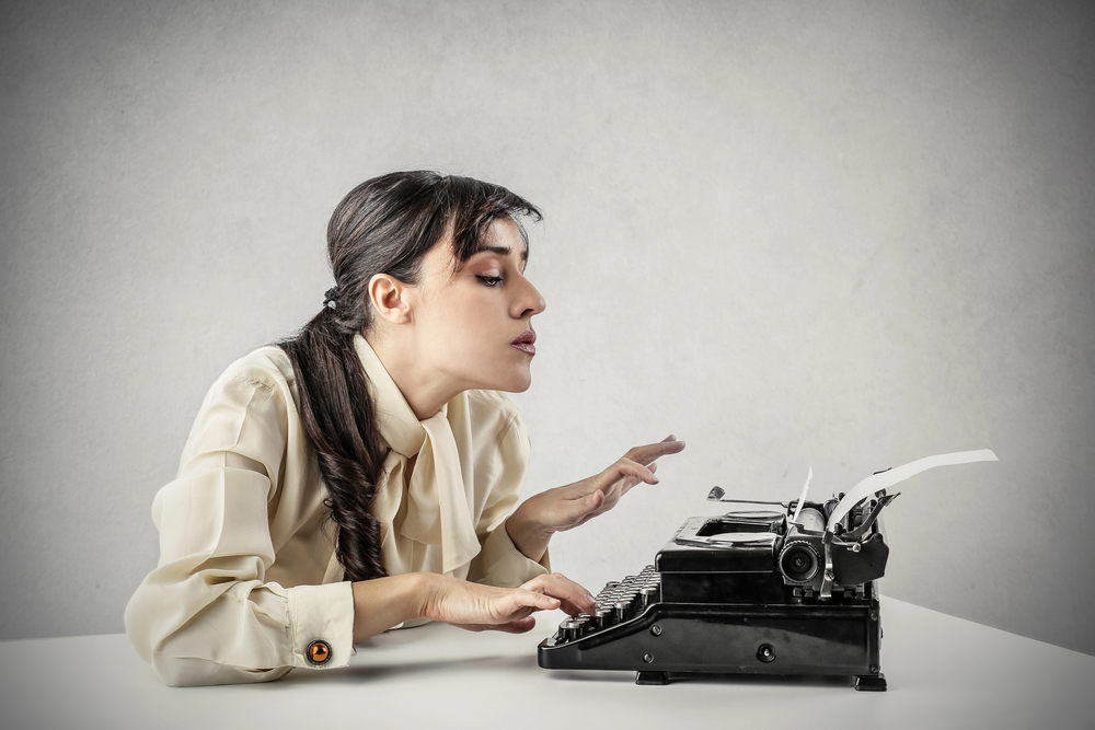 Women typing evergreen content on a typewriter.