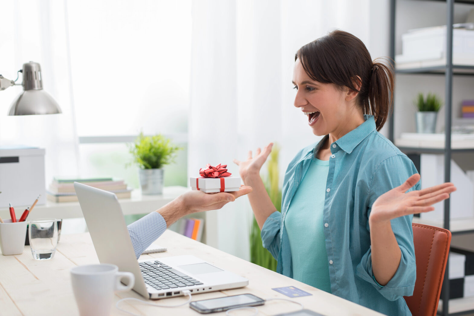 woman receiving a gift from a hand in computer as engaging content